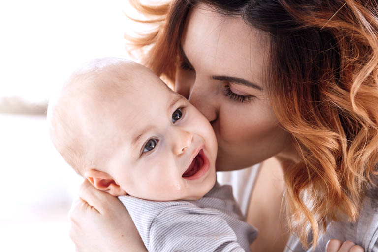 mama calmando a un bebe odontopediatrico saliendo los dientes de leche