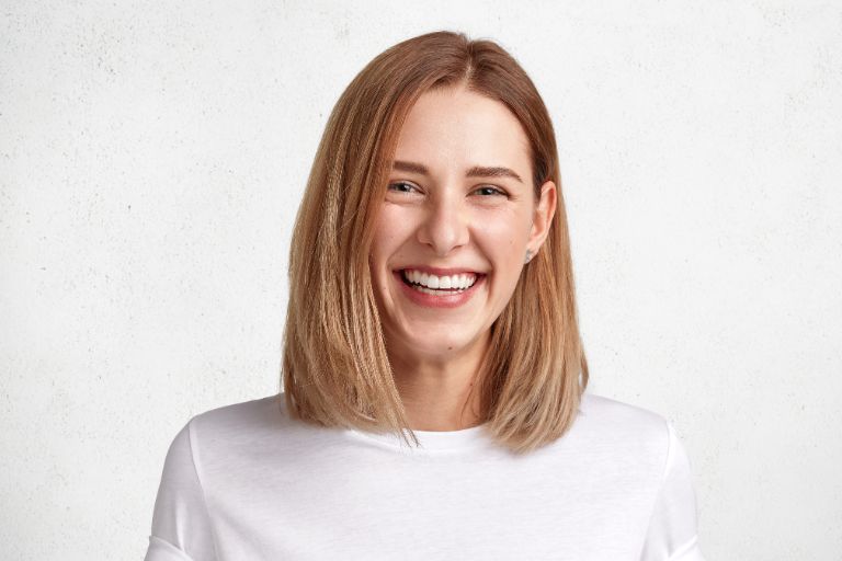 Mujer sonriendo a cámara - Tratamiento periodontal integral - Clínica Suarez Solís - Dentista en Avilés